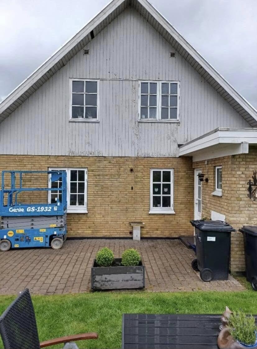 Murstenhus med lift og grøn forhave