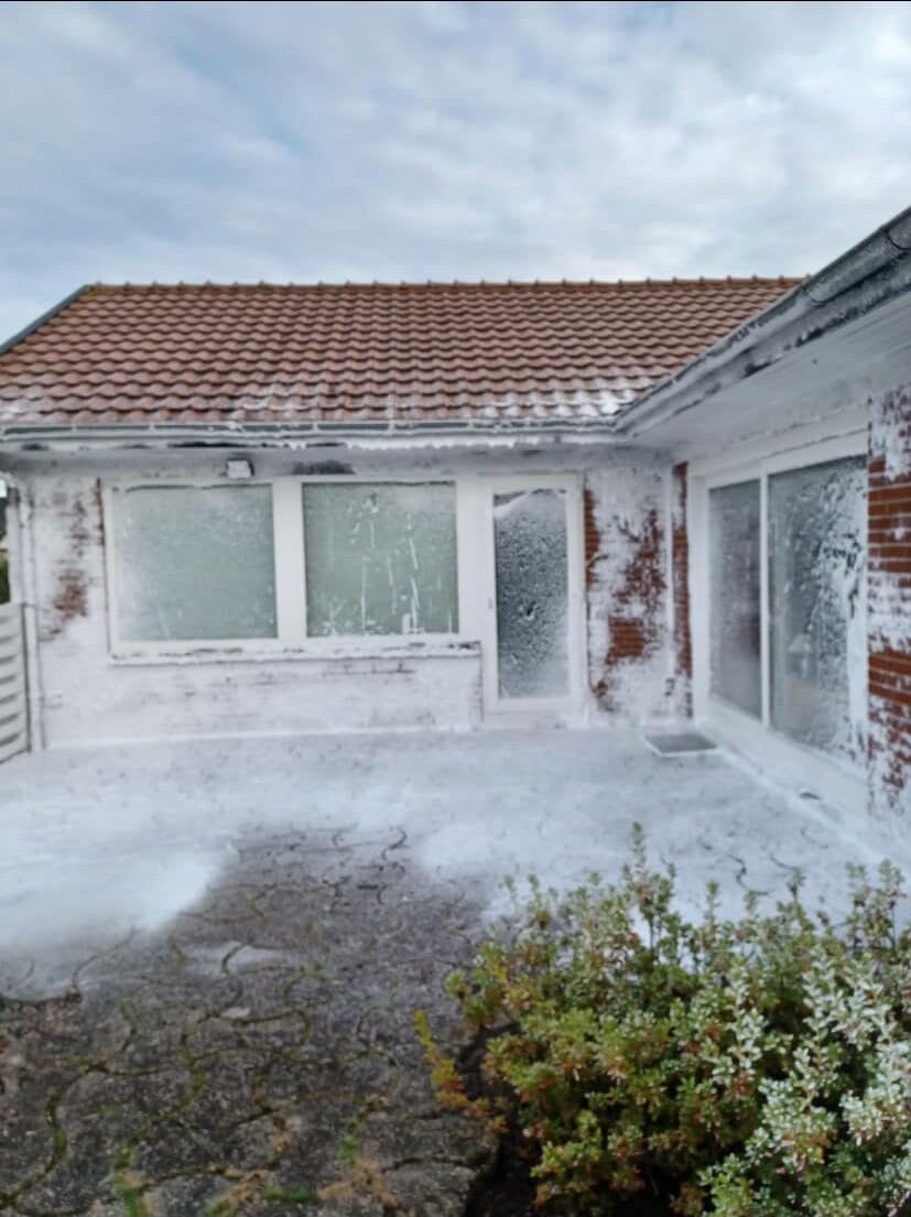 Hus dækket af hvidt skum efter facadevask
