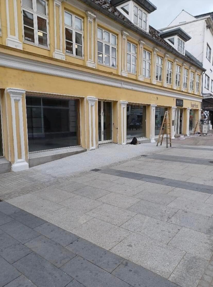 Gul bygning med butikker på gågade