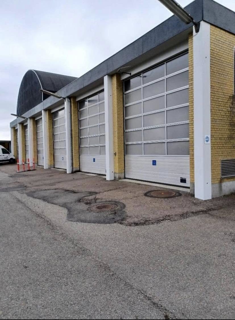 Garagebygning med lukkede porte og gul mursten